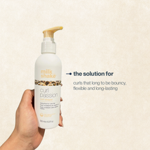 Load image into Gallery viewer, Hand holding a bottle of milk_shake Curl Passion product against a beige background