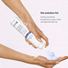 Load image into Gallery viewer, Hand holding a bottle of hair product with text about toning unwanted brassiness in hair color.