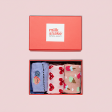 Load image into Gallery viewer, Set of three patterned socks in a box with 'milk shake' branding on a pink background.