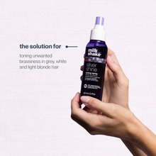 Load image into Gallery viewer, Hand holding a bottle of 'milk_shake' Silver Shine product against a light purple background