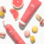 milk_shake Pink shampoo and conditioner bottles with macarons and grapefruit slices on a white background