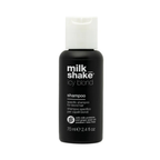 Black shampoo bottle with white cap labeled 'milk shake icy blond' on a white background