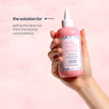 Load image into Gallery viewer, Hand holding a bottle of milk_shake product with text on a pink background
