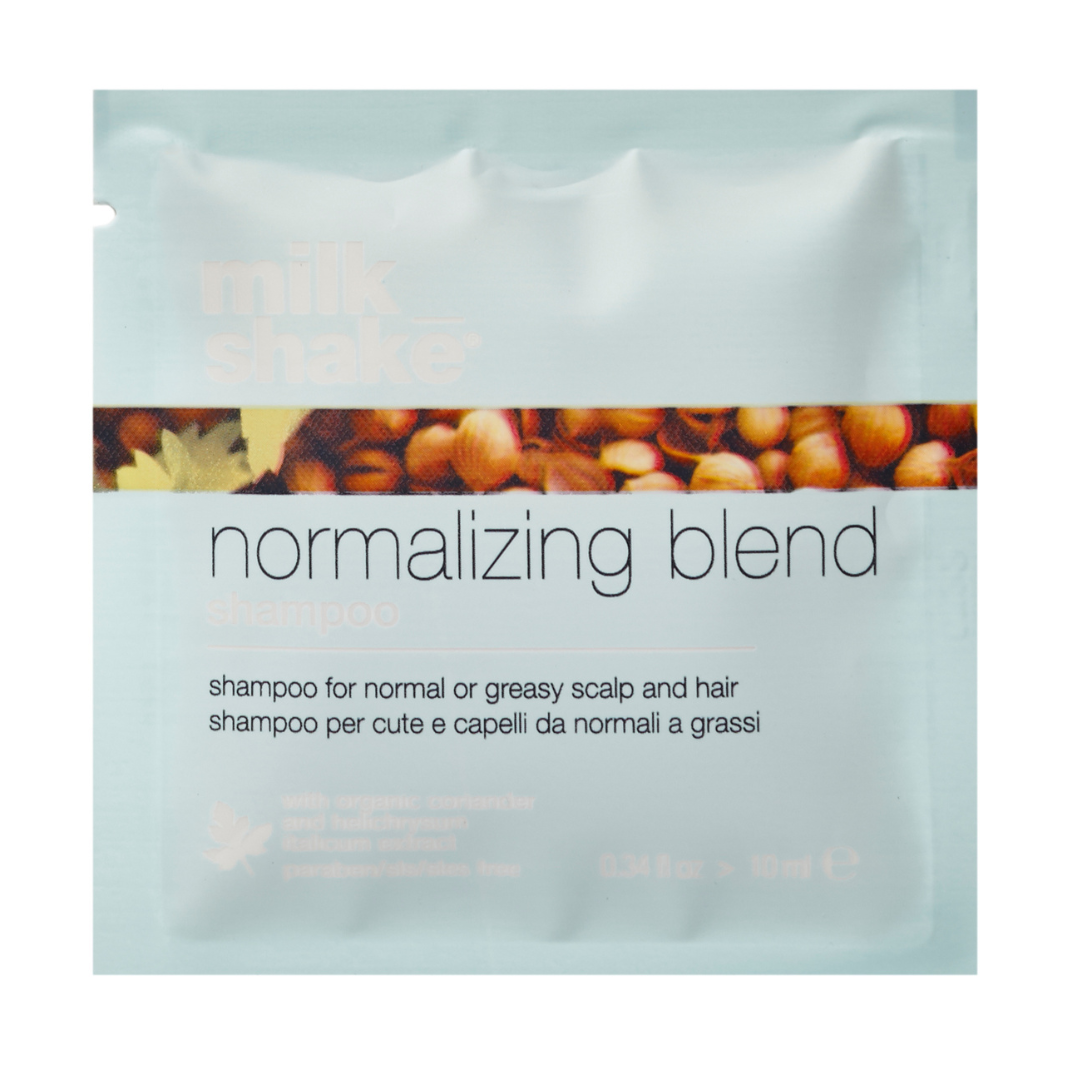 Shampoo packet labeled milk_shake 'normalizing blend' with a background of nuts.