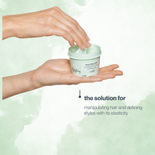 Load image into Gallery viewer, Hand holding a container of milk_shake  hair product with text about its elasticity benefits on a light green background
